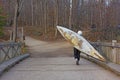 A person walking with a large kayak over his shoulder. Royalty Free Stock Photo